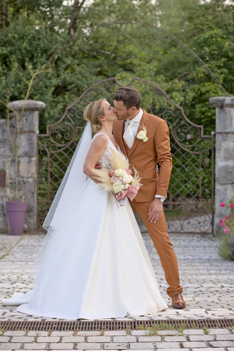 Amour dans l'allée Un couple qui s'embrasse juste avant le vin d'honneur. Du chic dégage de cette photo.