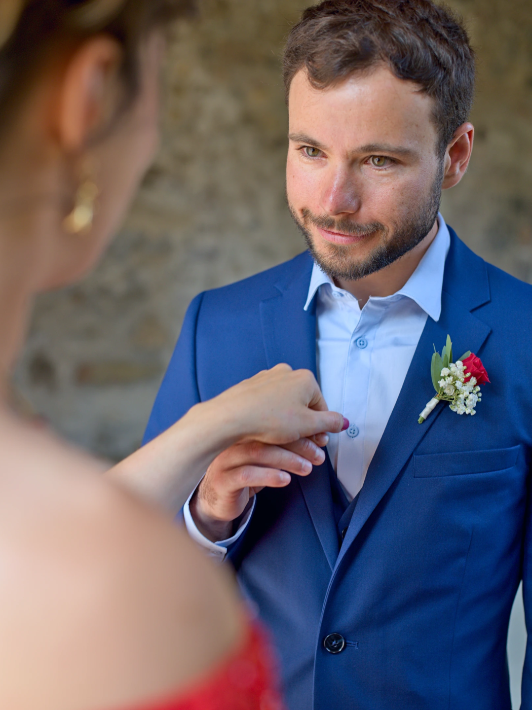 Le marié galant et charmant Photo prise juste avant la cérémonie civil à Grenoble. Le marié prend la main de la mariée et la regarde tendrement avec passion. Le marié est en costume bleu et la mariée est en robe rouge.