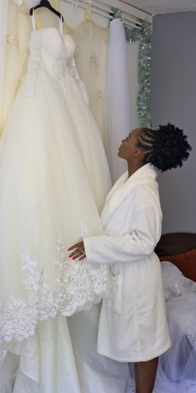 Le mariage, un rêve d'enfant qui commence à prendre vie Photographie prise durant les préparatifs. La mariée regarde sa robe encore accrochée au mur, tel un rêve d'enfance qui devient réalité.
