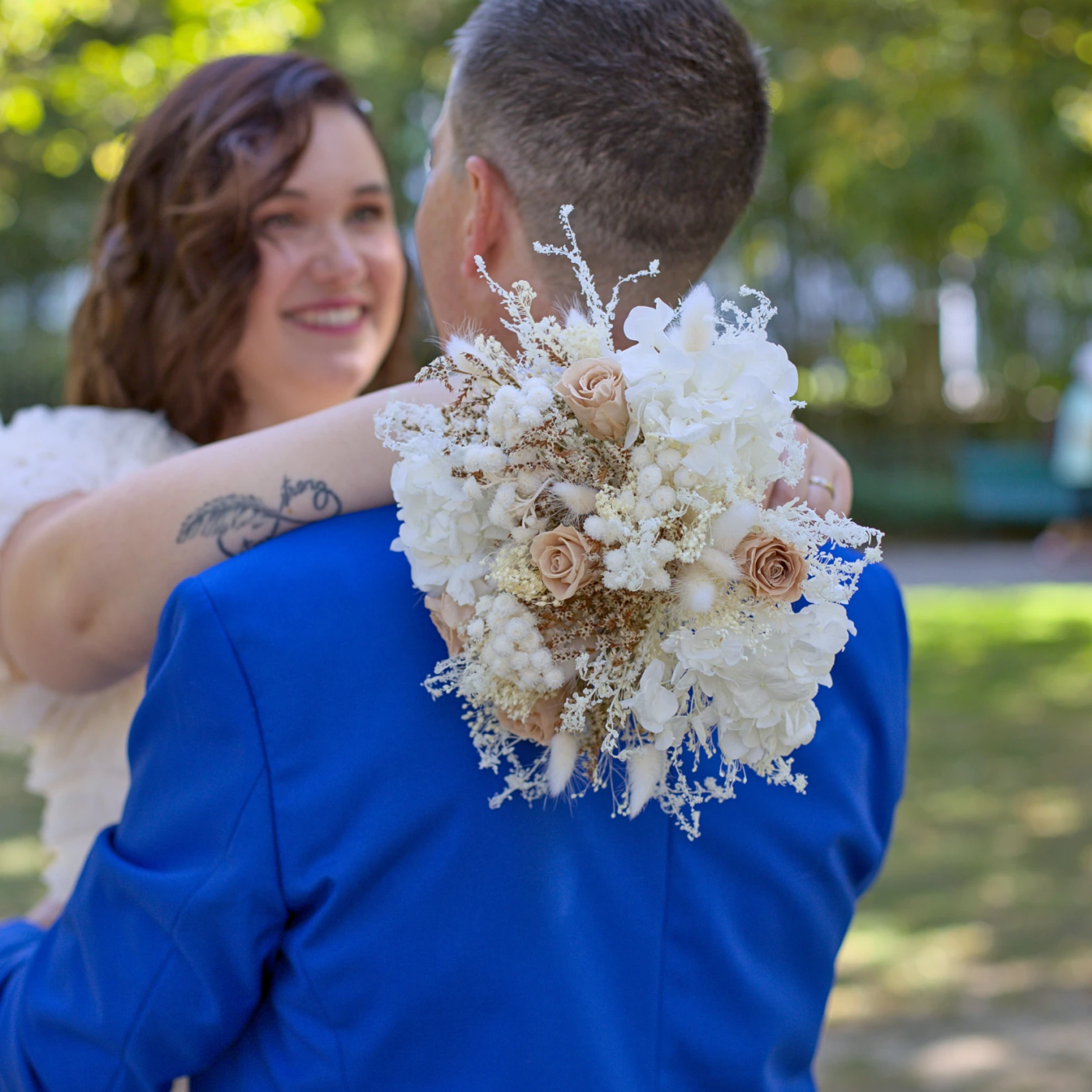 Derrière le bouquet Photo prise durant la séance couple de mariage à Grenoble. En premier plan le bouquet tenue par la mariée, en second plan les deux mariés qui se font face. Un moment de complicité et d'intimité authentique capturé.